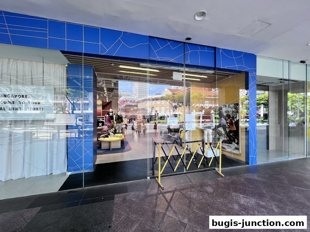 The entrance to a modern Nike store with a bright blue and yellow facade.
