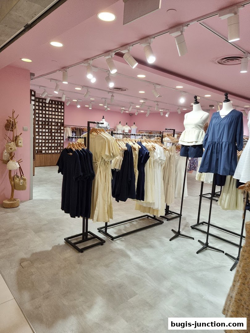 Interior view of a clothing store with racks of dresses and mannequins.