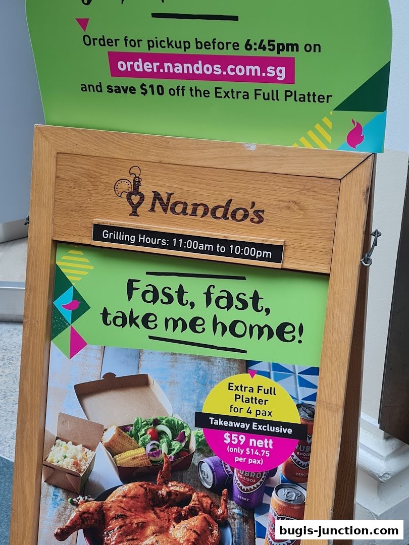 A Nando's sign advertising a takeaway platter with grilled chicken, sides, and drinks.