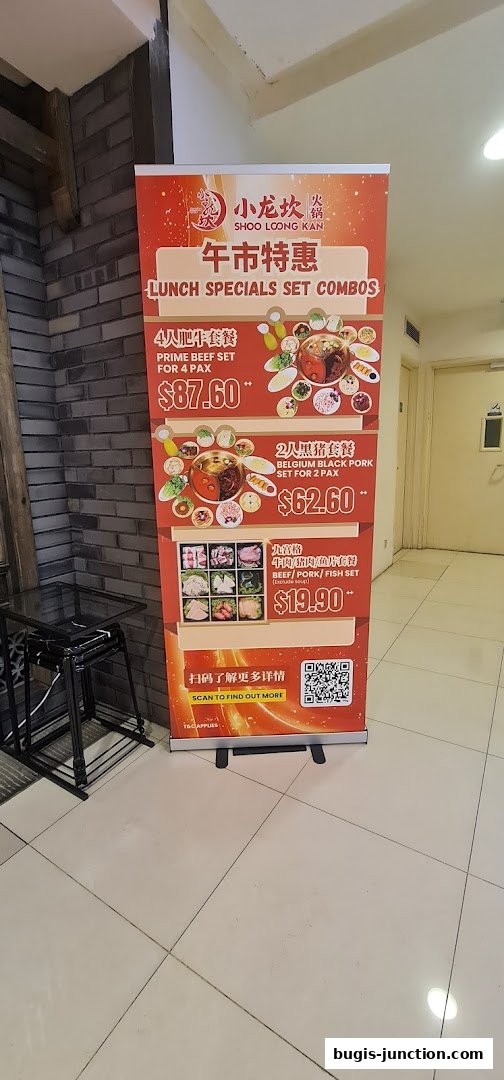 A pull-up banner advertising lunch specials and set combos for Xiao Long Kan Hotpot.