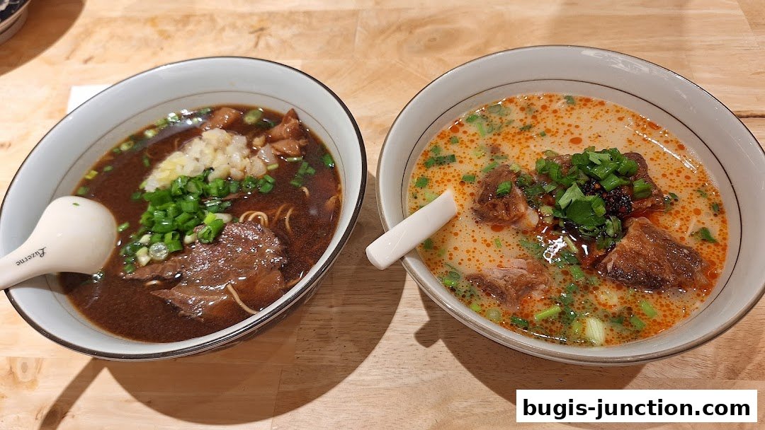 Two bowls of delicious noodle soup, one with dark broth and beef, the other with a creamy broth and meat.