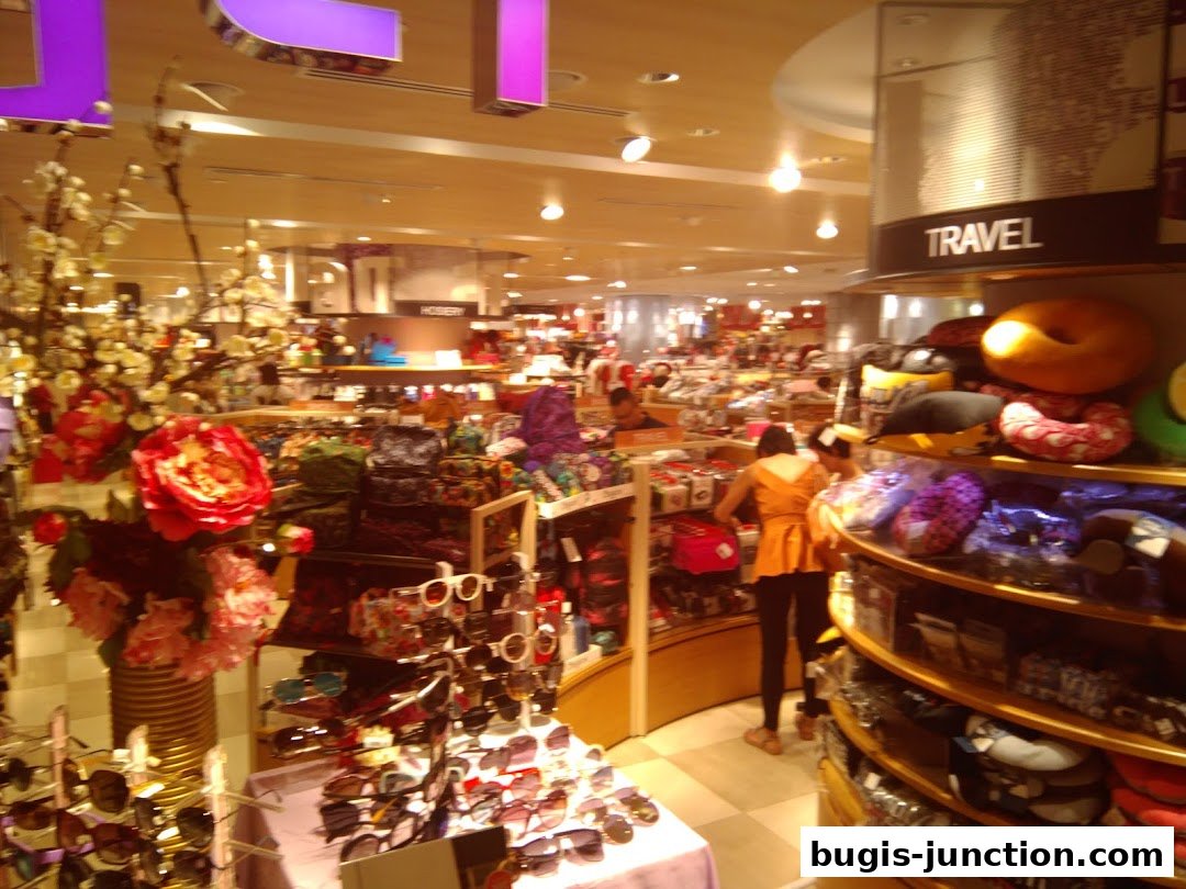 Interior of a department store with various merchandise, including accessories and travel items.