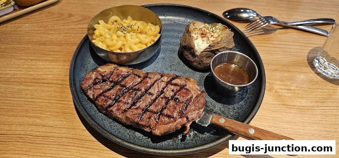 A perfectly grilled steak with mac and cheese, baked potato, and dipping sauce.