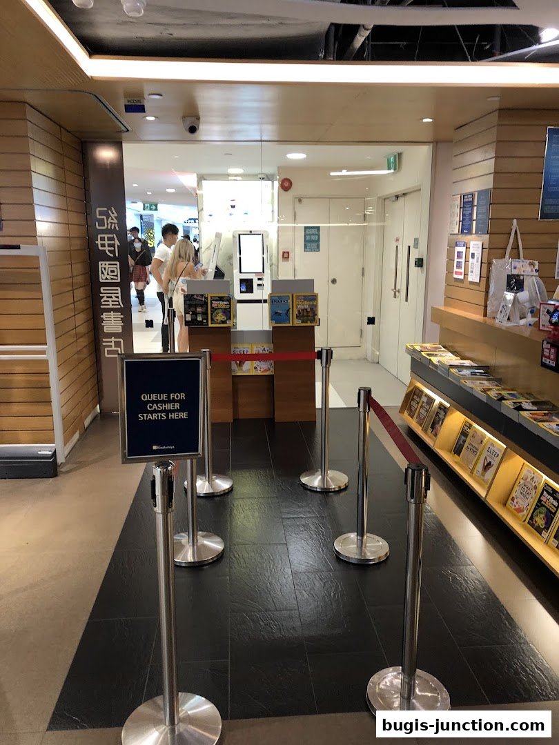 The entrance to Books Kinokuniya Bugis Junction with a queue management system.