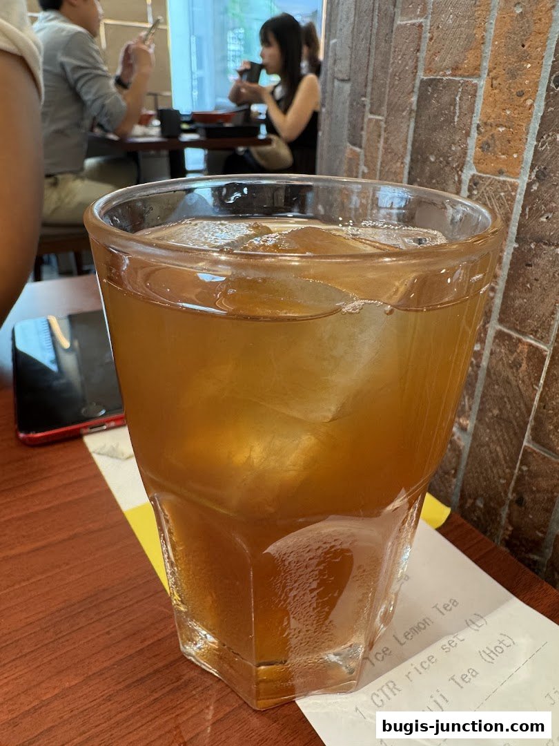 A close-up of a glass of iced tea with a receipt visible below.