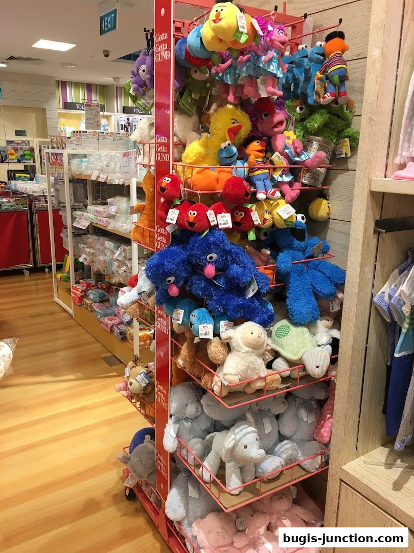 A display rack filled with various plush toys, including Sesame Street characters and other stuffed animals.