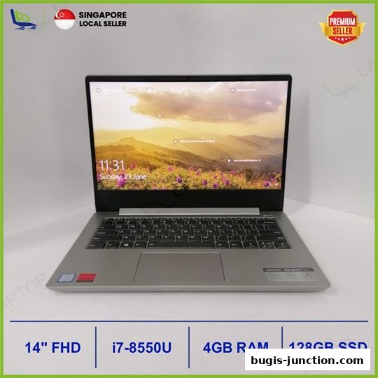 A silver laptop with a scenic wallpaper is displayed, featuring key specifications at the bottom.