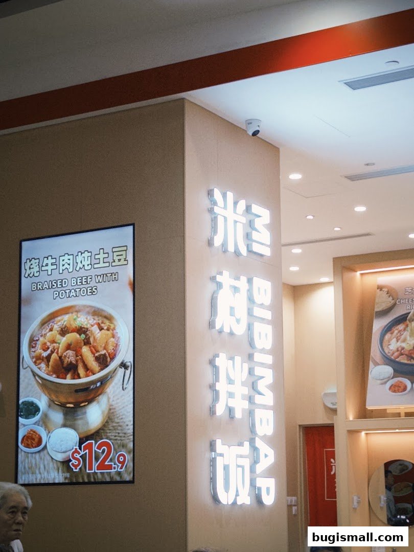 A sign for MICUN BIBIMBAP restaurant displays a dish of braised beef with potatoes for $12.9.