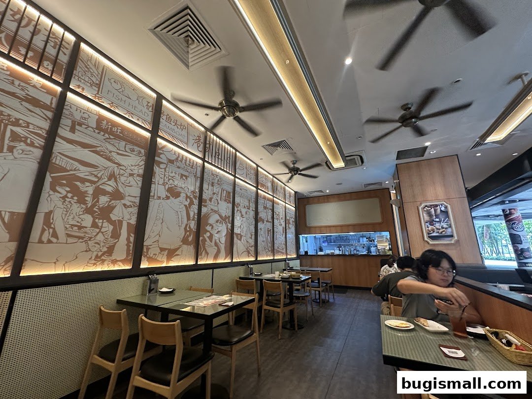 Interior of a Hong Kong-style cafe with decorative murals and dining tables.