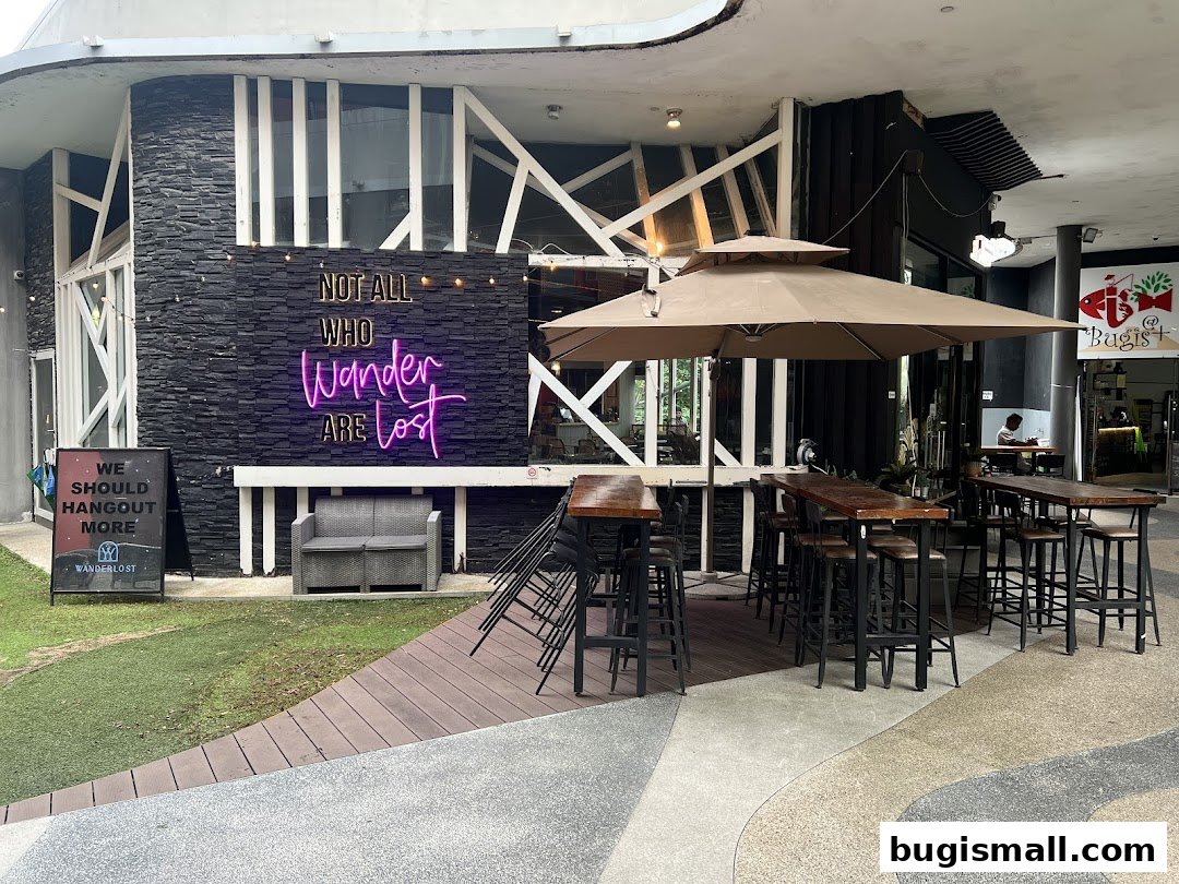 The exterior of Wanderlost Lounge with outdoor seating and a neon sign.