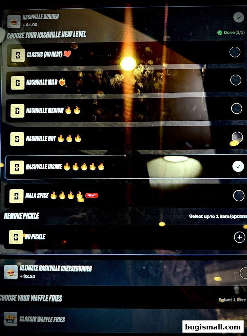 A digital menu displaying Nashville burger heat levels and waffle fries options.