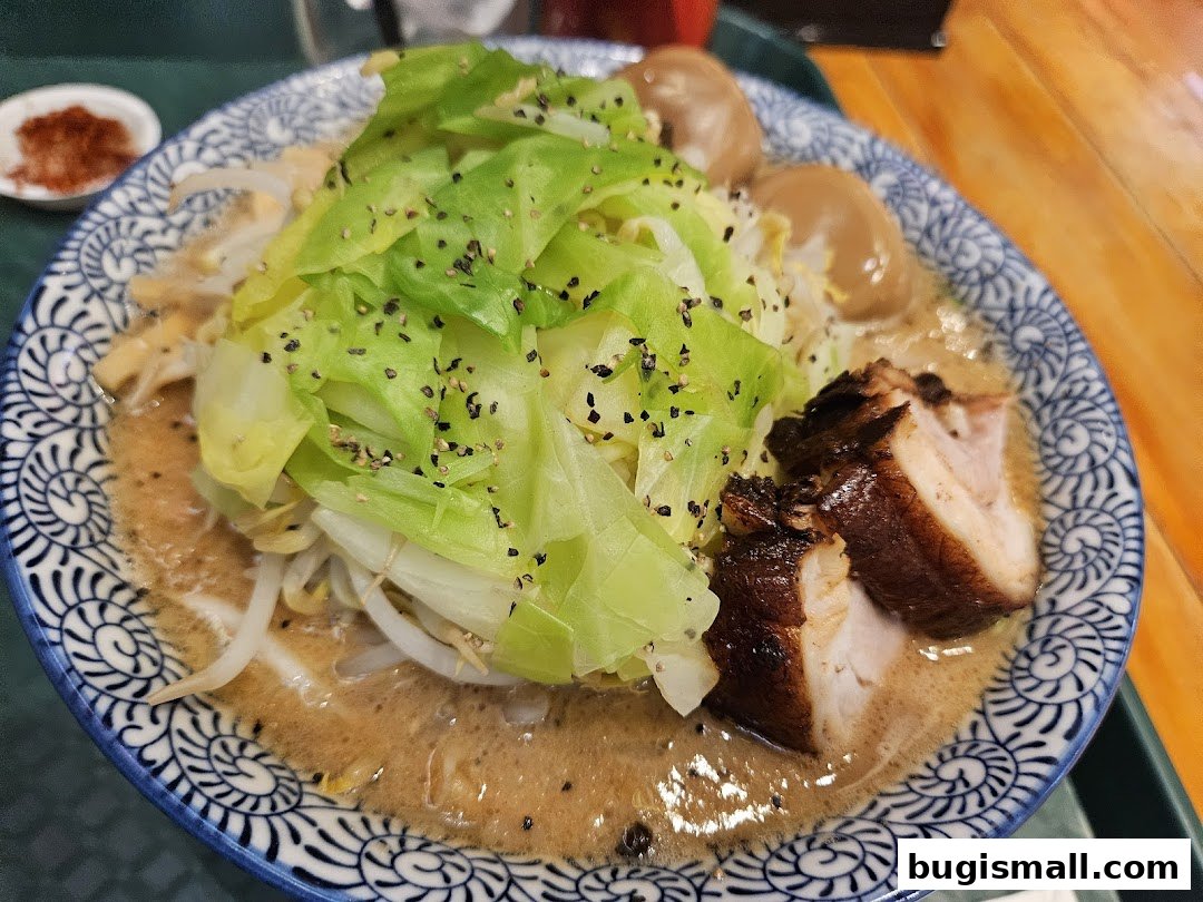 A close-up of a delicious ramen bowl with pork, eggs, and vegetables.