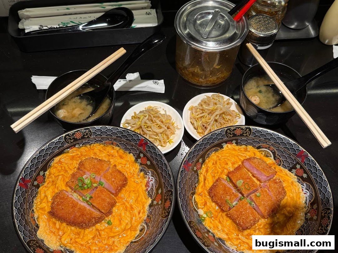Two bowls of scrambled egg rice with fried pork cutlet and a side of bean sprouts and miso soup.