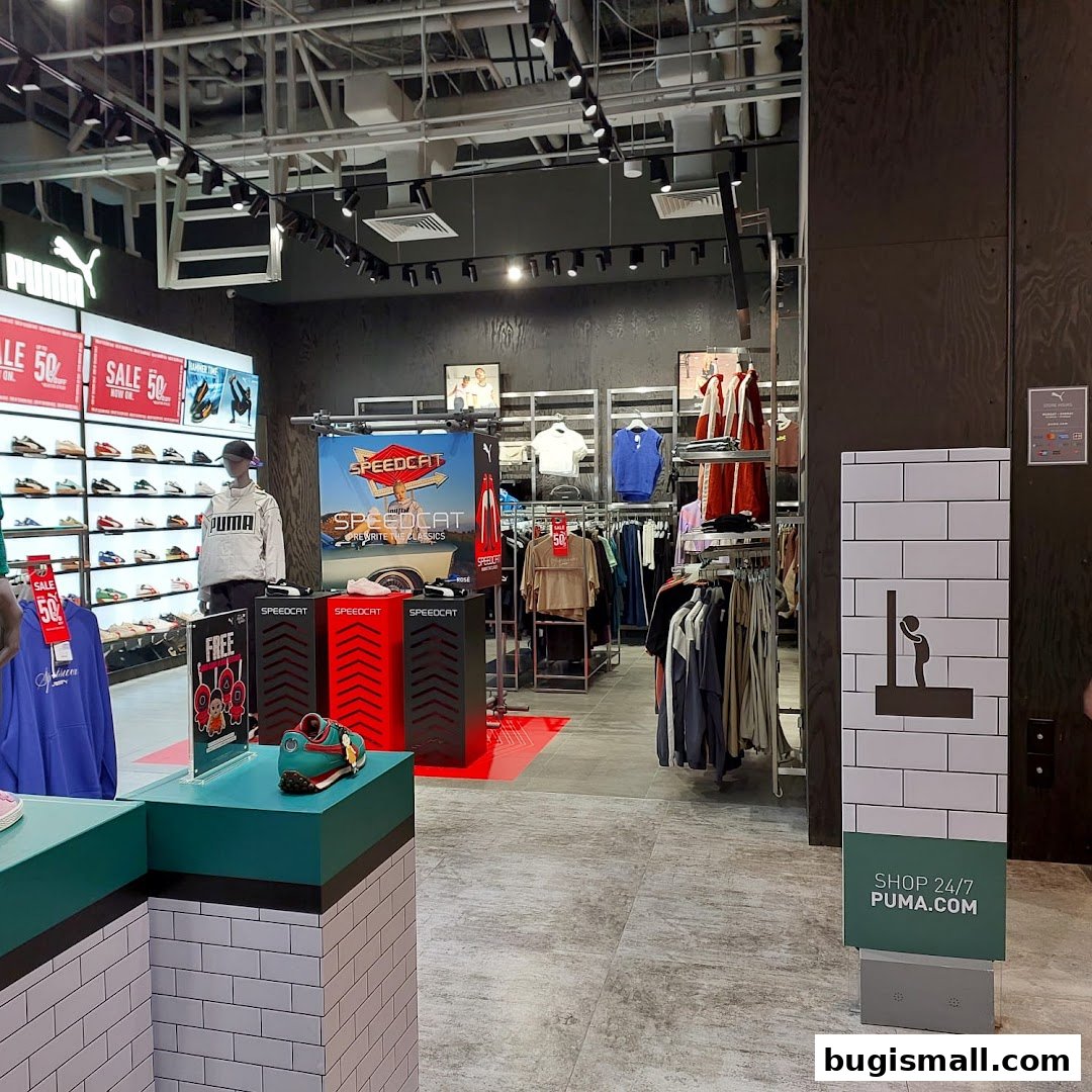 Interior view of a PUMA store showcasing apparel, footwear, and sale promotions.