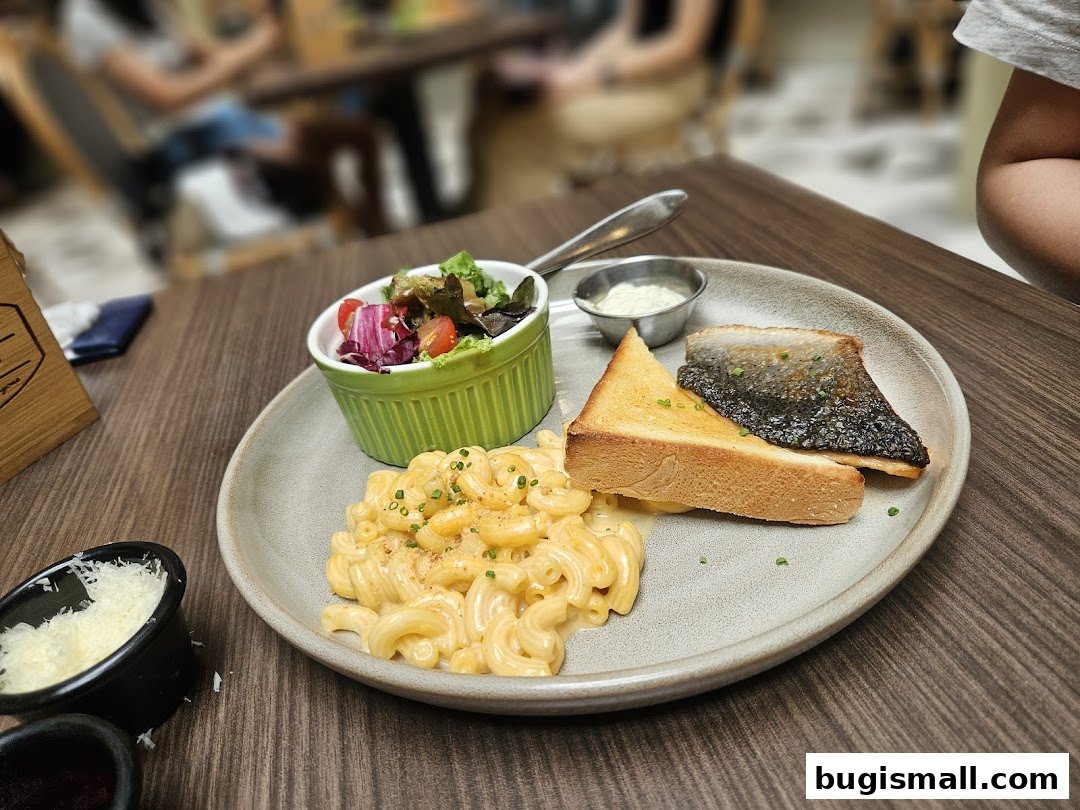 A plate of mac and cheese, salad, and fish with toast and sauce.