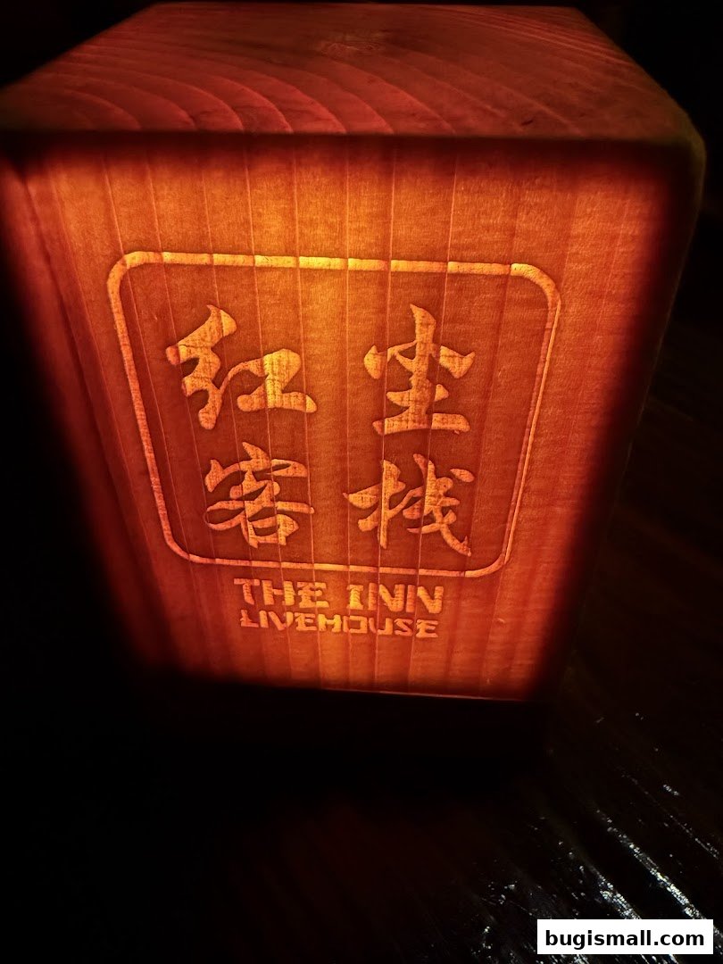 A close-up of a wooden lantern with illuminated Chinese characters and the text 'THE INN LIVEHOUSE'.