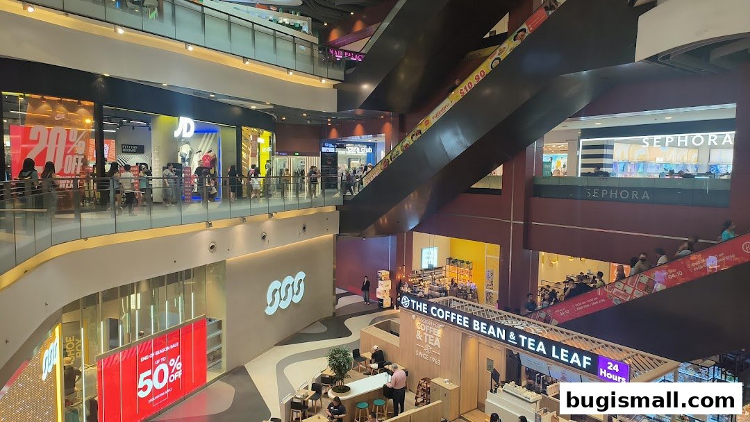 A multi-level shopping mall interior with various stores including JD Sports and Sephora.