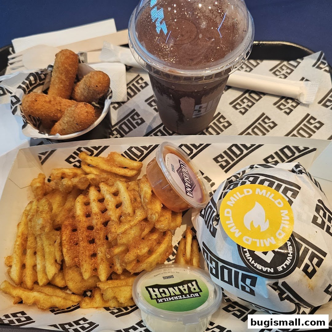 A meal from SIDES featuring waffle fries, mozzarella sticks, a burger, and a drink.
