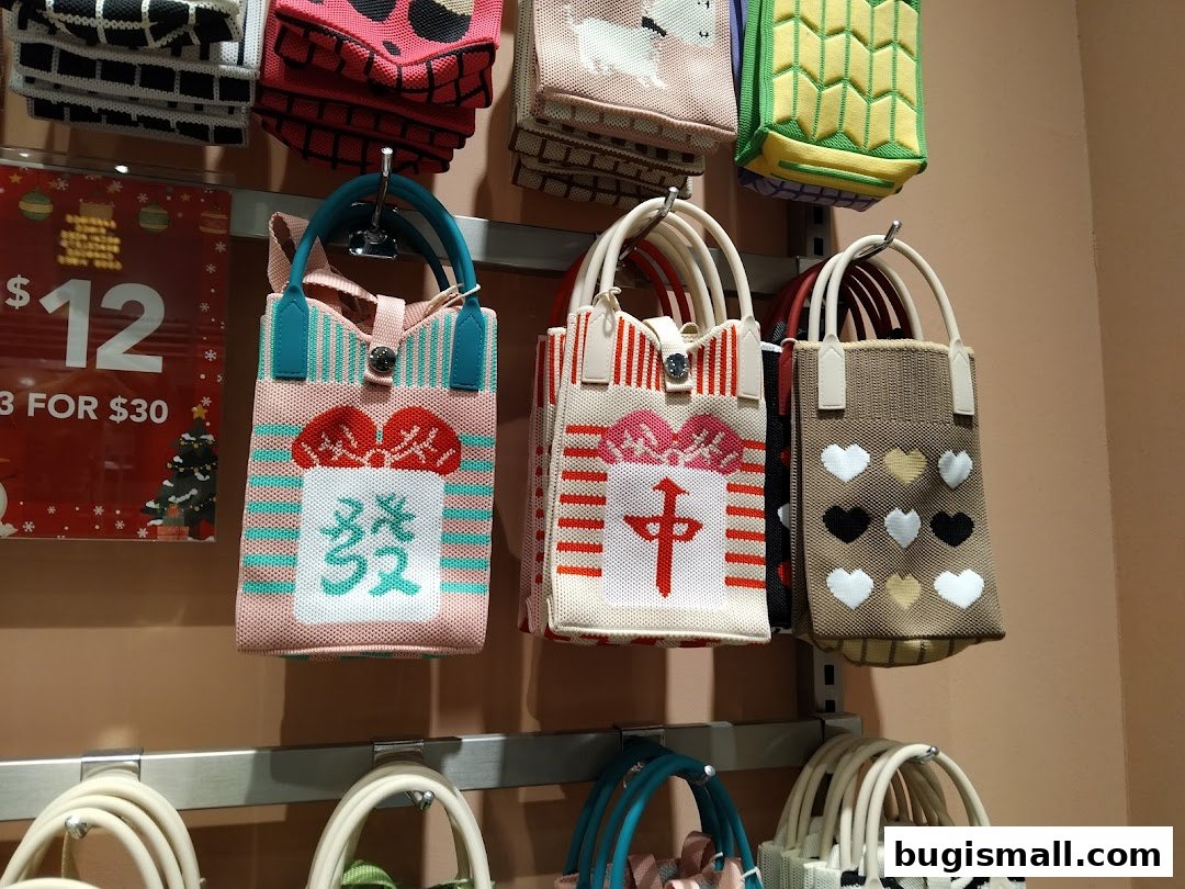 A display of colorful knitted bags with various designs, including hearts and Chinese characters.
