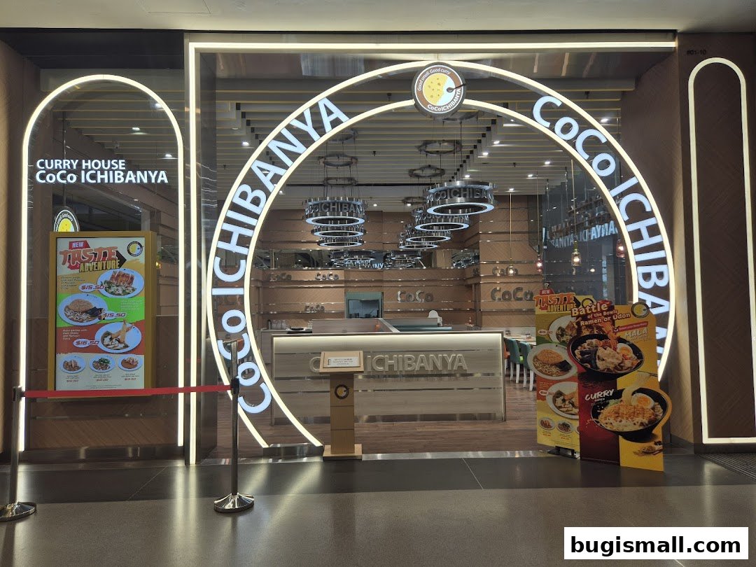 The entrance of CoCo ICHIBANYA, a Japanese curry restaurant, with illuminated signage and food displays.