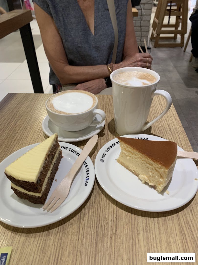 Two slices of cake and two cups of coffee are served on a wooden table.