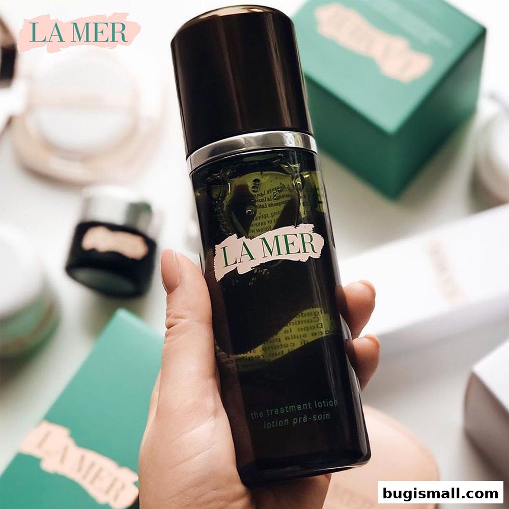 A hand holds a bottle of La Mer The Treatment Lotion surrounded by other La Mer products.