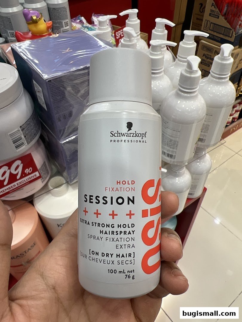 A hand holds a Schwarzkopf Professional hairspray bottle in a retail store.