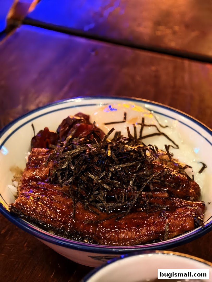 A close-up of a delicious unagi donburi dish with grilled eel and seaweed.