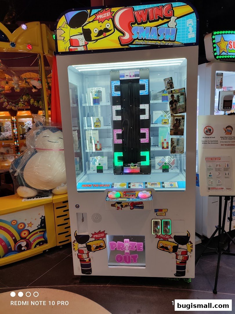 A "Swing Smash" arcade prize machine with various prizes inside.