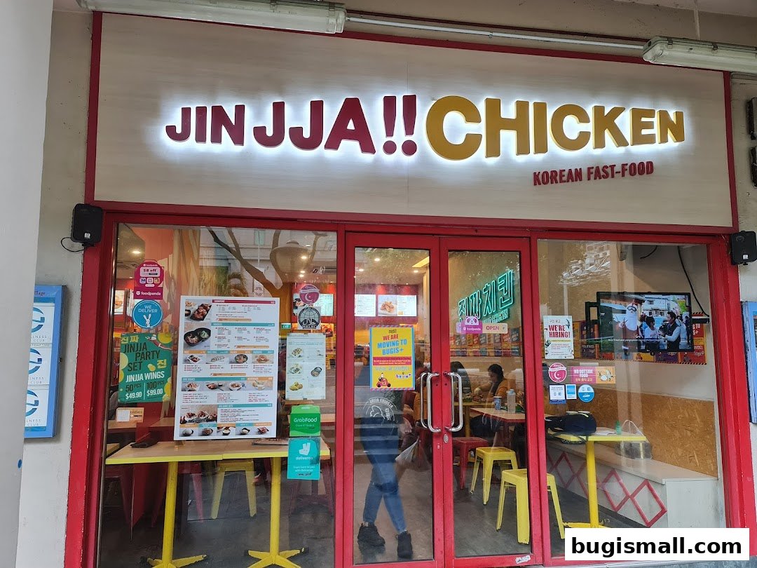 The exterior of JINJJA Chicken, a Korean fast-food restaurant, with its prominent signage and glass doors.