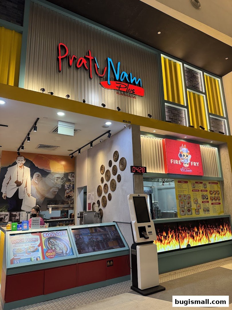 The entrance of Pratunam PLUS by Soi Thai Soi Nice, featuring a vibrant storefront with menu displays and a self-order kiosk.