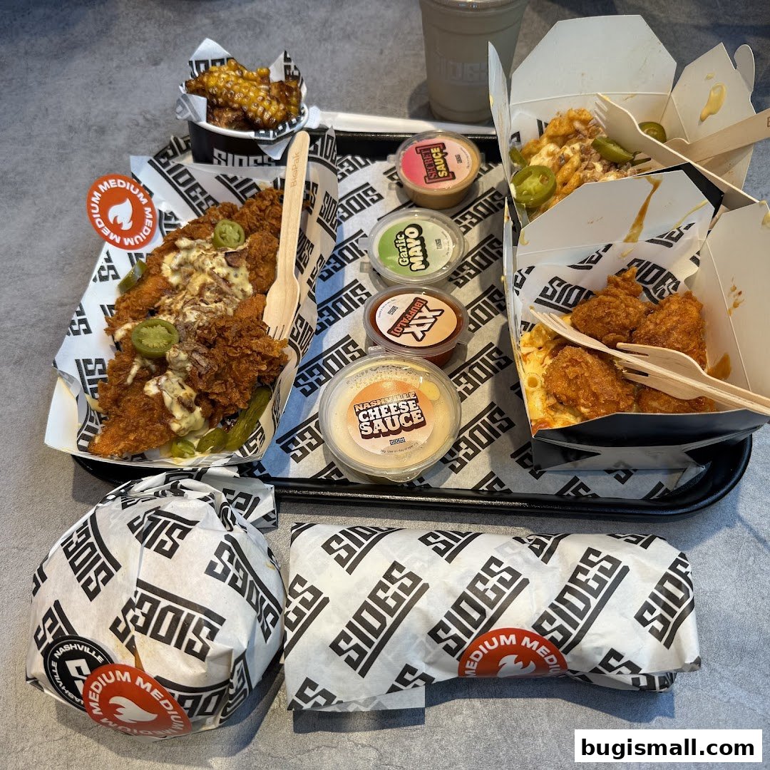 A tray of fried chicken, mac and cheese, and sauces from SIDES.