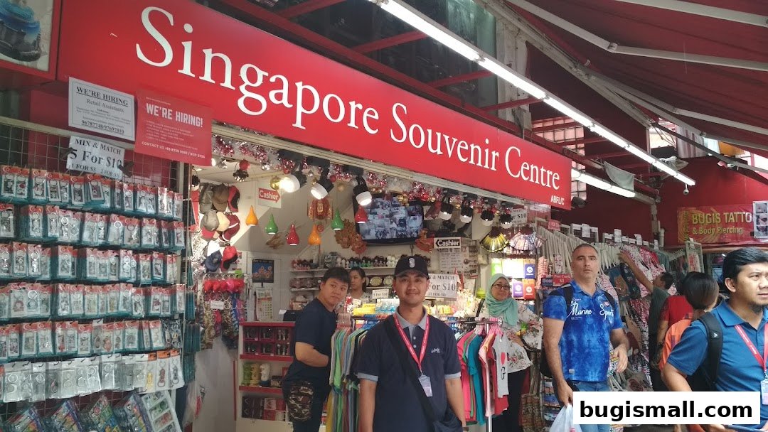 A bustling souvenir shop with a large red sign and displays of keychains and apparel.