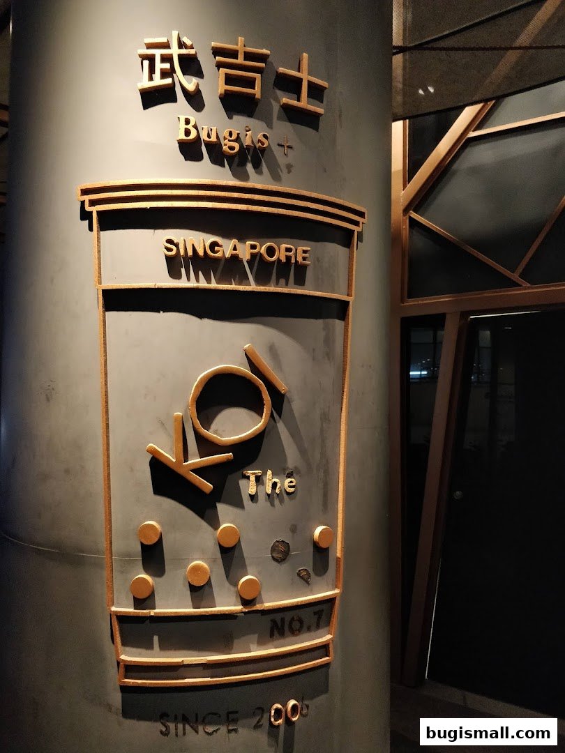 A sign for KOI Thé Bugis, featuring the brand logo and location.