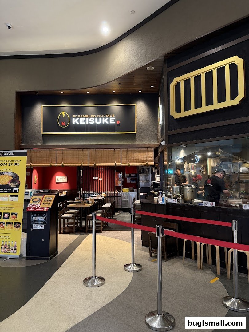 The entrance and dining area of Scrambled Egg Rice Keisuke, with a prominent sign and queue barriers.