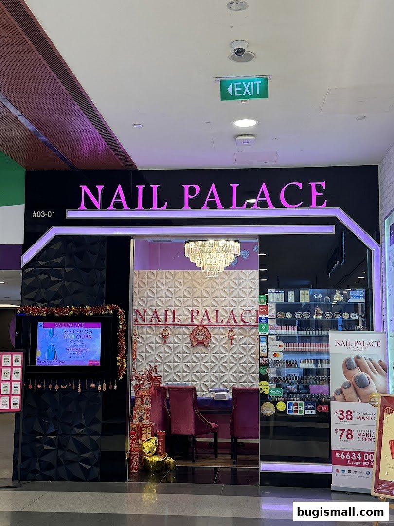 The entrance of Nail Palace, a nail salon, with promotional posters and a display of nail products.