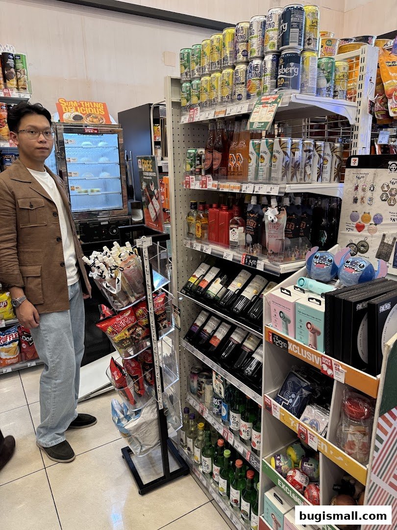 A man stands in a 7-Eleven store aisle with shelves stocked with drinks and snacks.