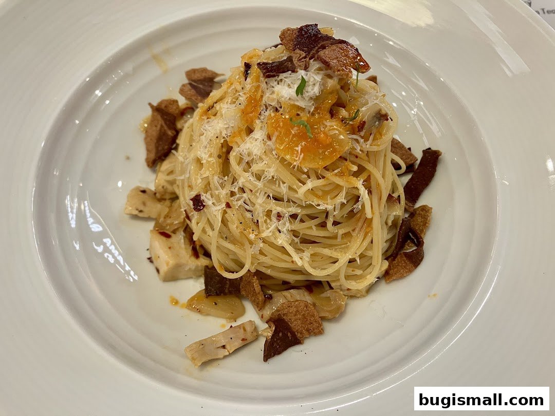A close-up of a delicious pasta dish with shredded cheese and crispy toppings.