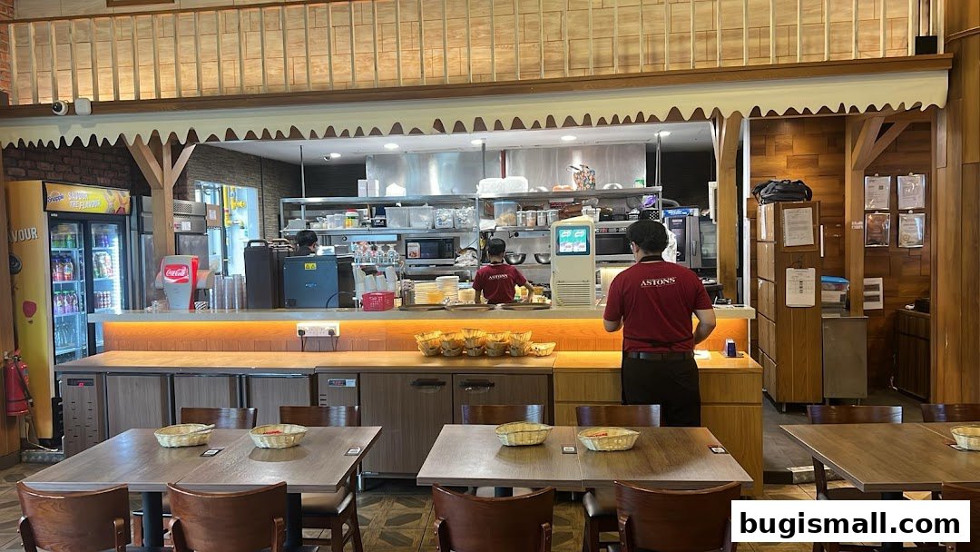 Interior view of the ASTONS restaurant with dining tables and staff at the counter.
