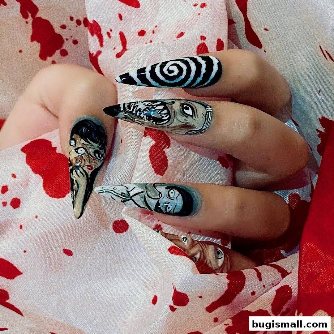 Close-up of a hand with intricately designed horror-themed nails against a blood-splattered fabric.