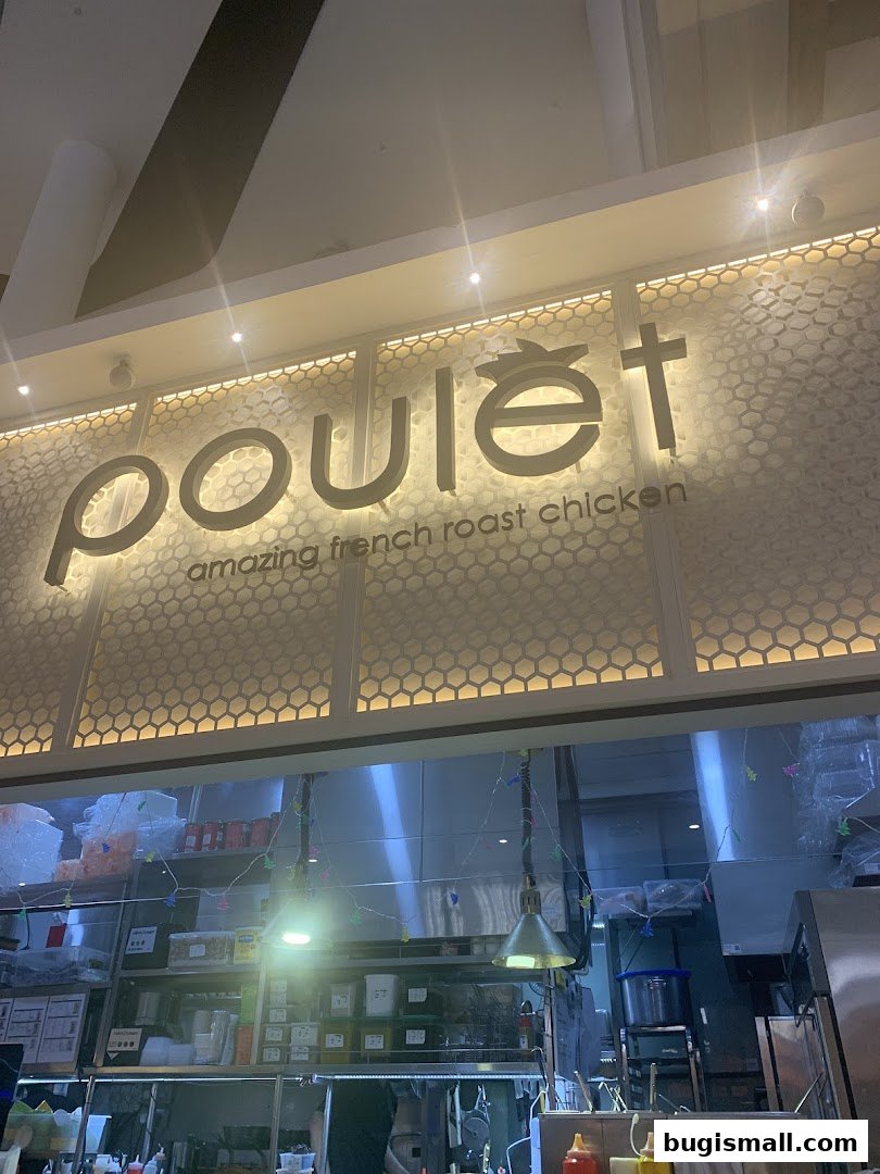 The illuminated sign for Poulet, advertising amazing French roast chicken.