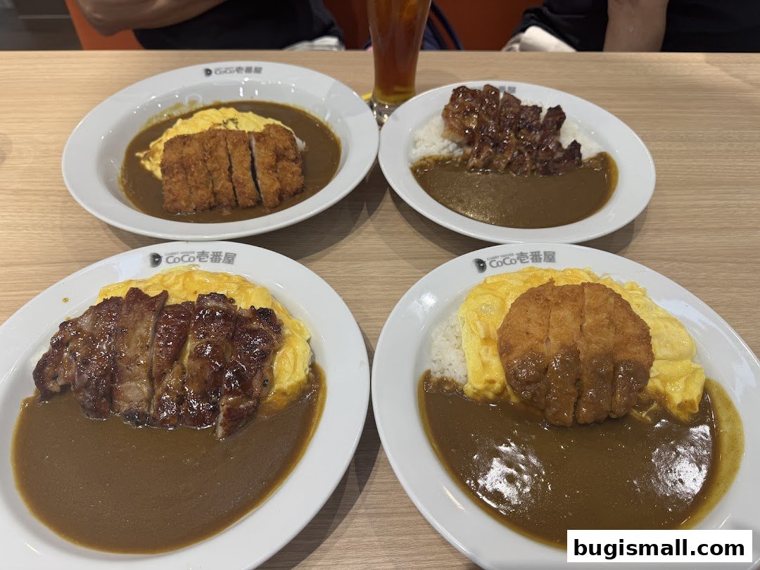 Four plates of Japanese curry rice with various toppings, including fried chicken and pork.