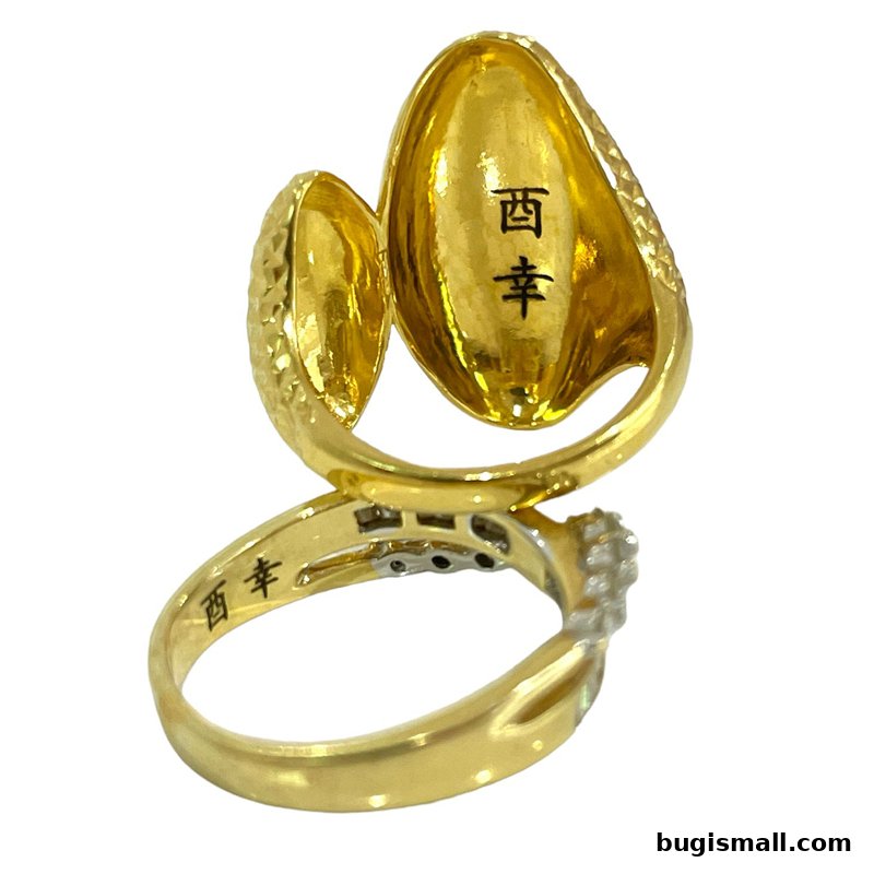 A close-up shot of a gold ring with Chinese characters inscribed inside.