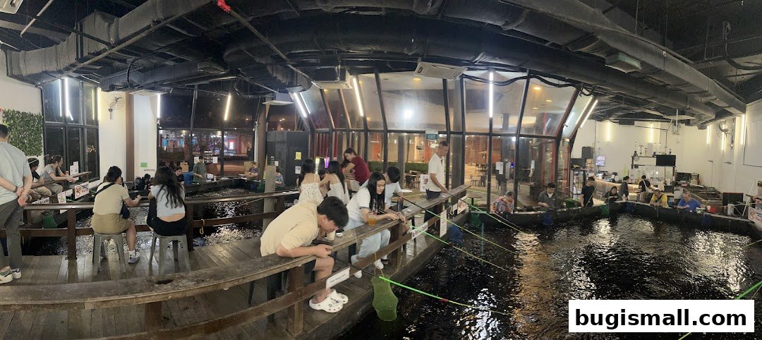 People fishing in an indoor pond at a restaurant.