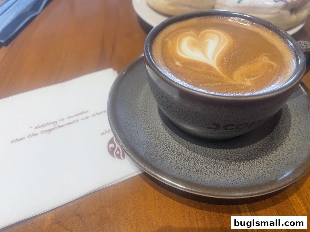 A cup of coffee with latte art on a saucer next to a napkin.