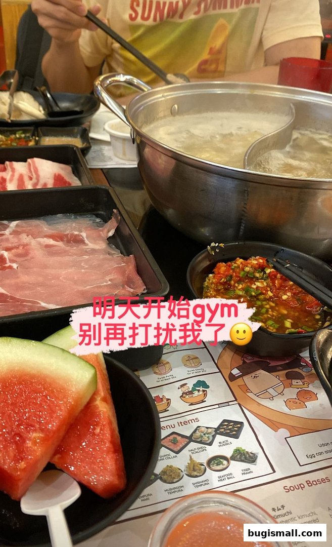 A table laden with shabu shabu ingredients, including thinly sliced meat, watermelon, and dipping sauces.