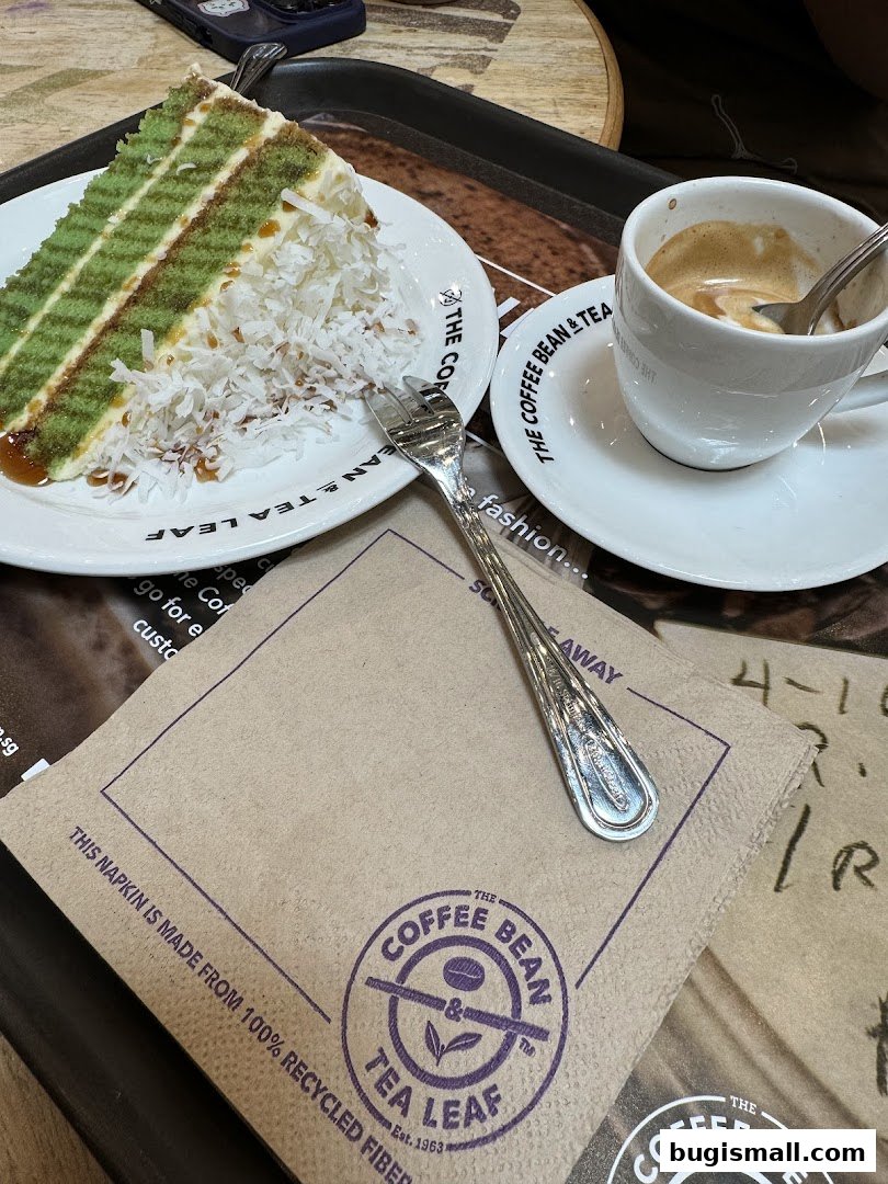 A slice of green layered cake with coconut and a cup of espresso at The Coffee Bean & Tea Leaf.