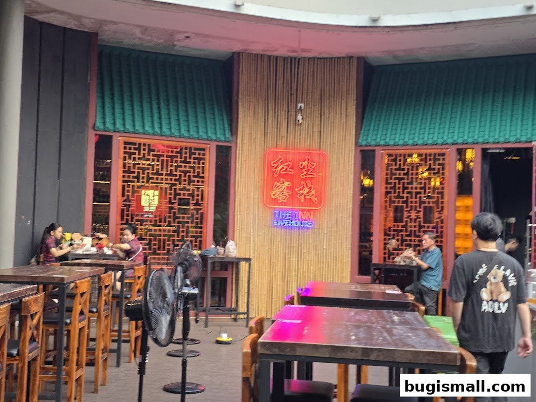 The Inn Livehouse Bugis features a vibrant entrance with neon signs and traditional Chinese decor.