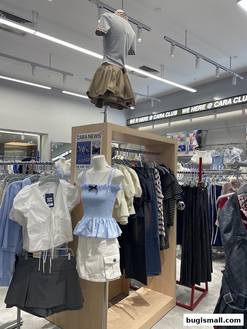 A clothing store display featuring mannequins dressed in trendy outfits and racks of apparel.