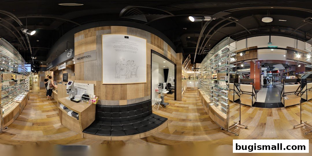Interior view of an eyeglasses shop with displays of frames and a reception area.